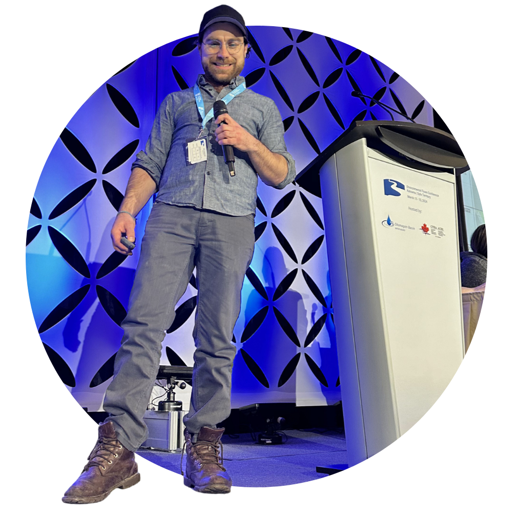 Speaker at the 2024 Environmental Flows Conference in Kelowna, B.C. presenting on stage. 
